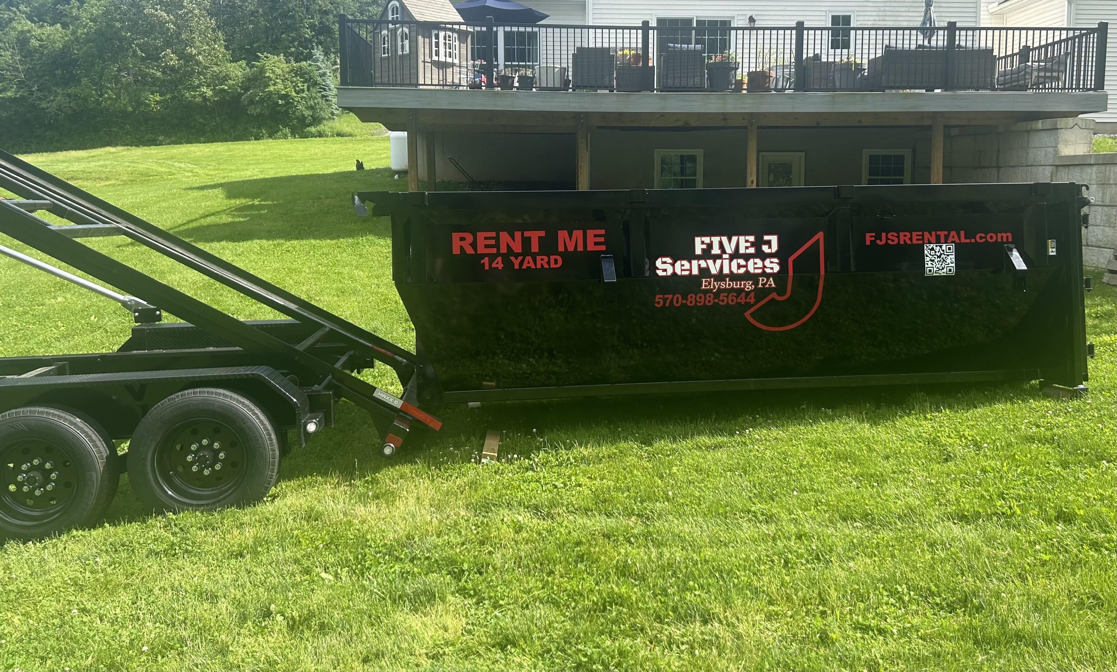 A large black boat sitting in the grass.